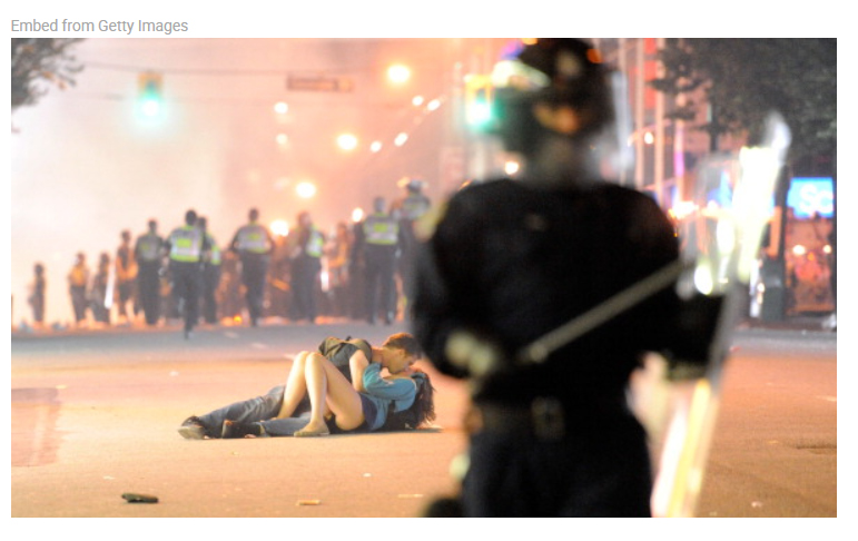 Riot police walk in the street as a couple kiss on June 15, 2011 in Vancouver, Canada. Vancouver broke out in riots after their hockey team the Vancouver Canucks lost in Game Seven of the Stanley Cup Finals. Rich Lam/Getty Images